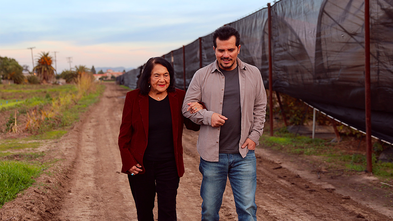 John Leguizamo walking arm and arm with Dolores Huerta