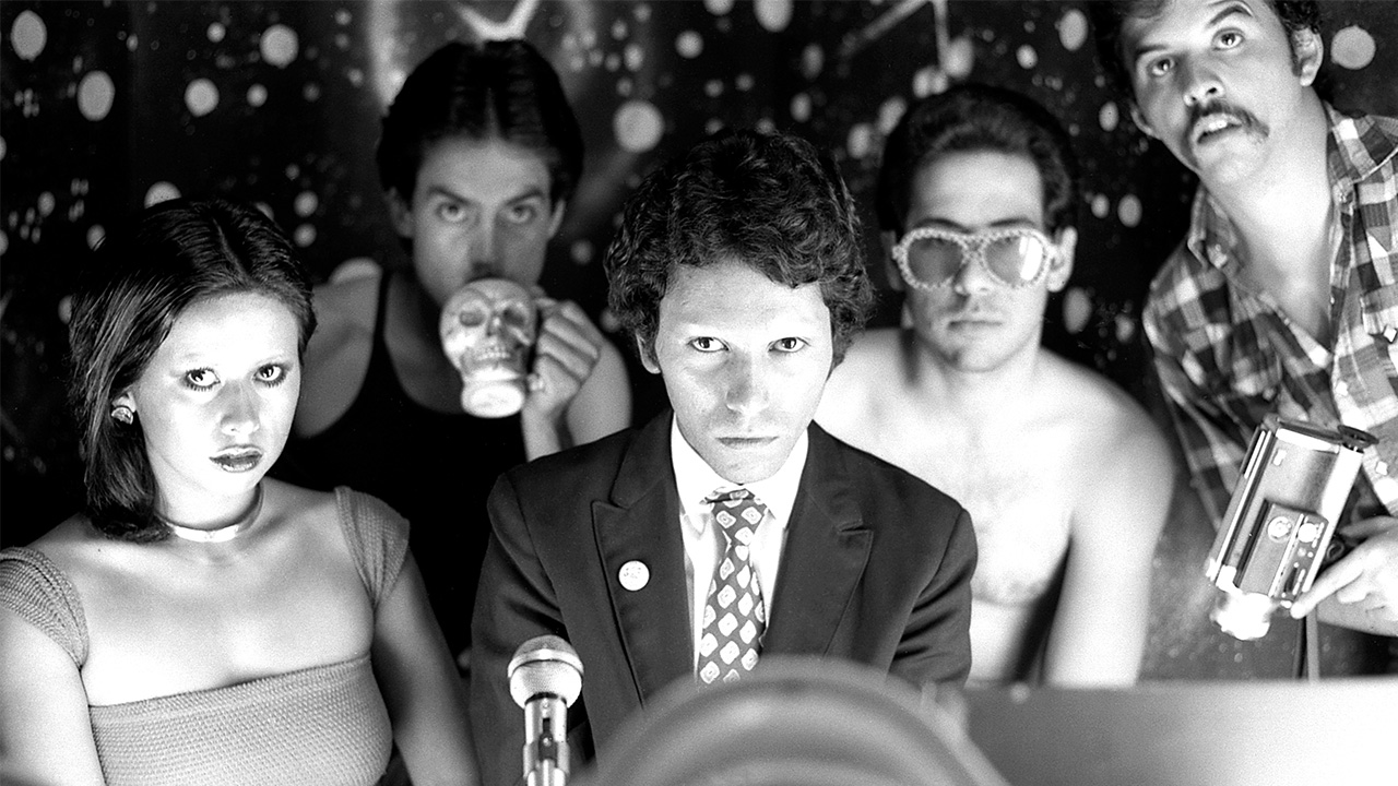 black and white film photo of five young people all dressed differently but staring at the camera