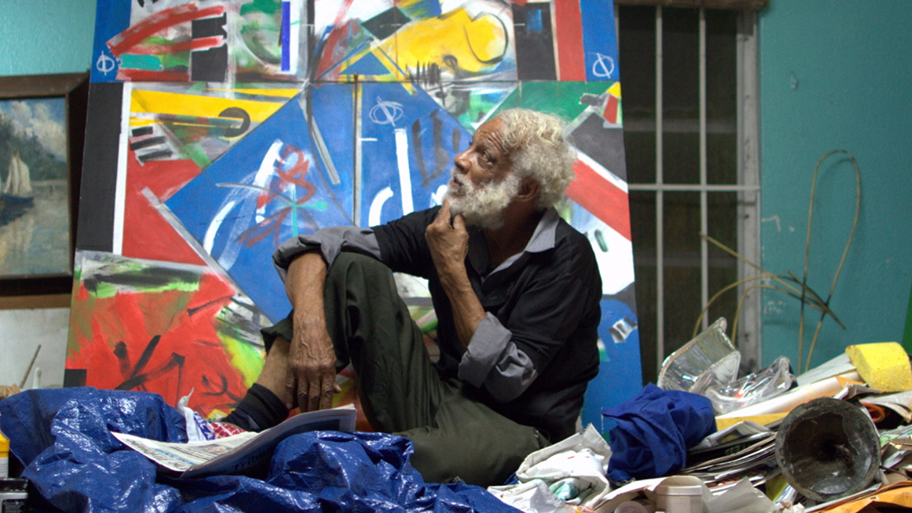 Man sitting infront of painting looking into distance
