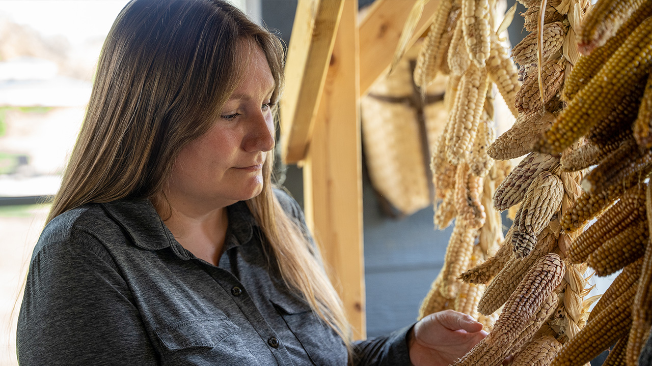 woman looking at drying corn 