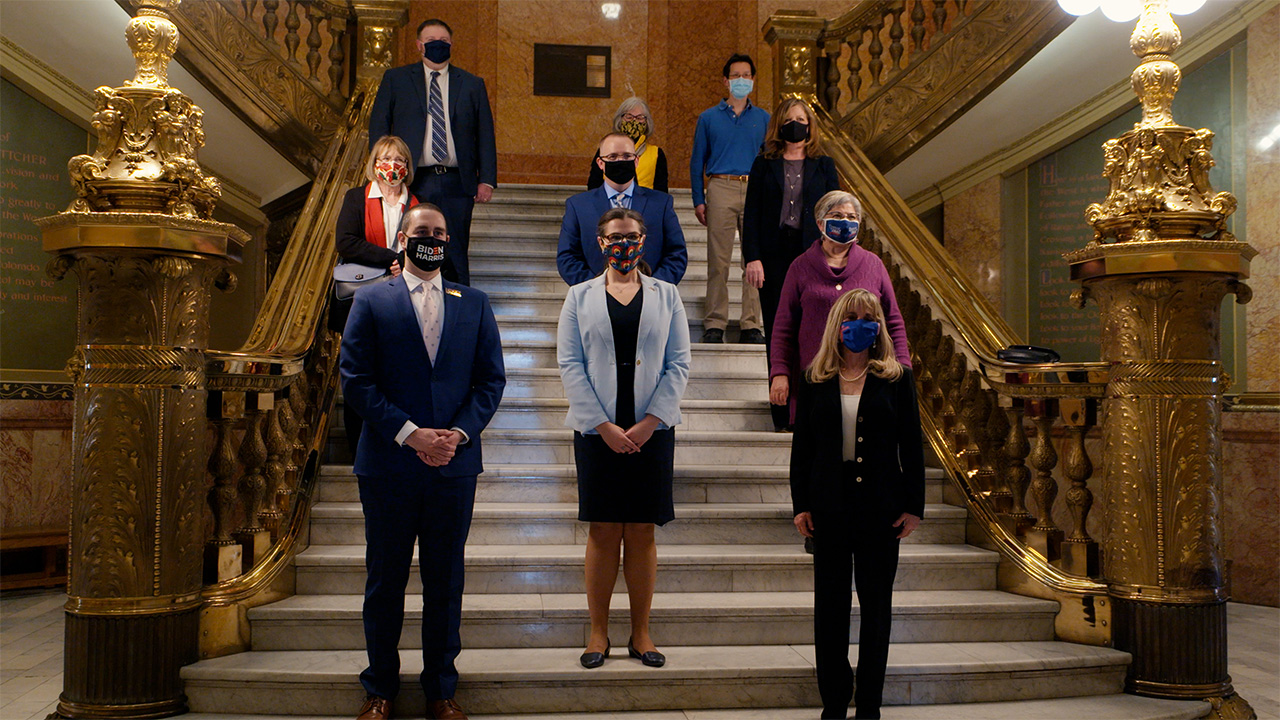 Group of people standing on stairs wearing mask looking serious
