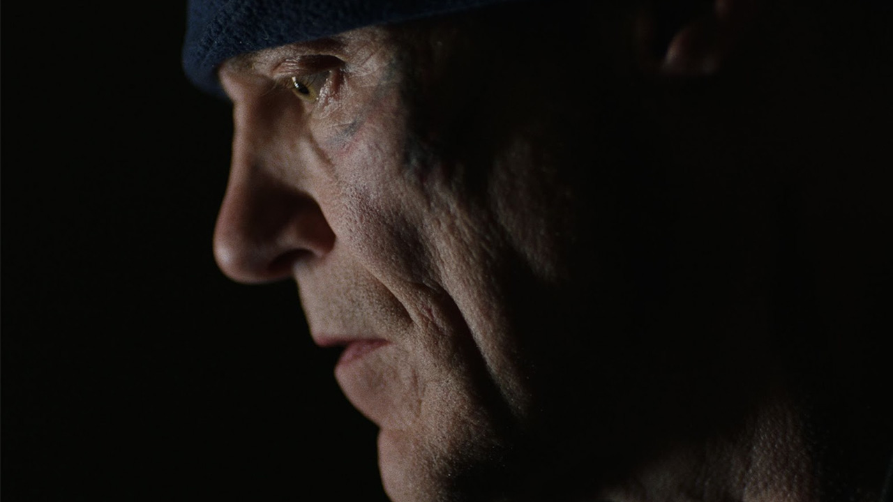 Man with tattoos on his face looking at something off camera